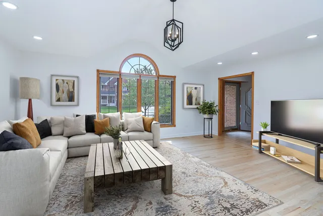 a living room with furniture a flat screen tv and a table