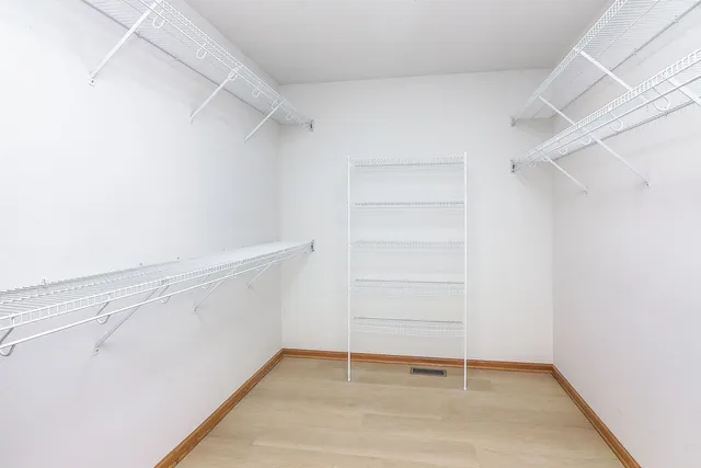 a view of walk in closet with empty racks