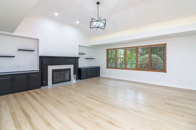 a view of an empty room with a fireplace and a window