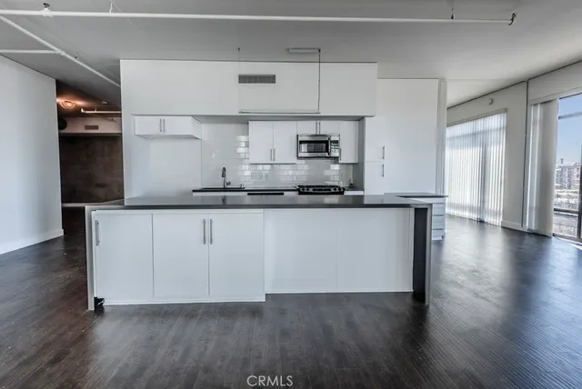 a kitchen with stainless steel appliances a stove and white cabinets