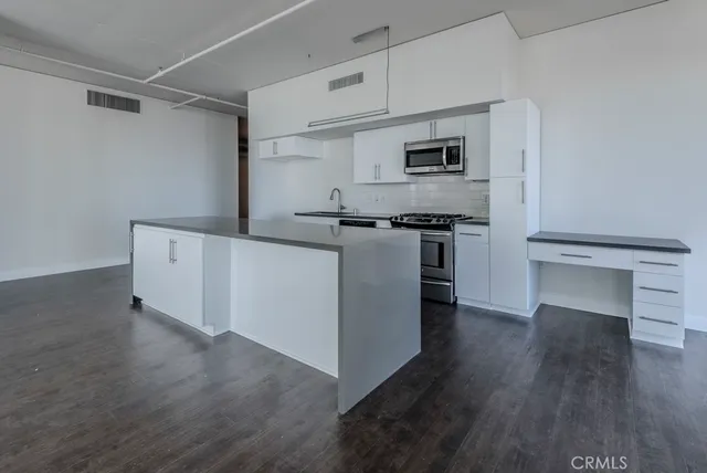 a kitchen with stainless steel appliances granite countertop a stove and wooden cabinets