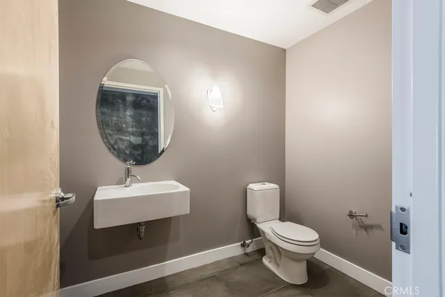 a bathroom with a toilet a sink and mirror