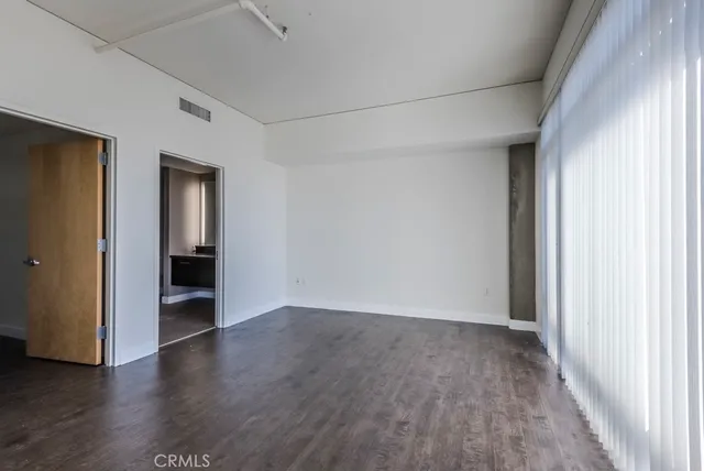 an empty room with wooden floor and closet