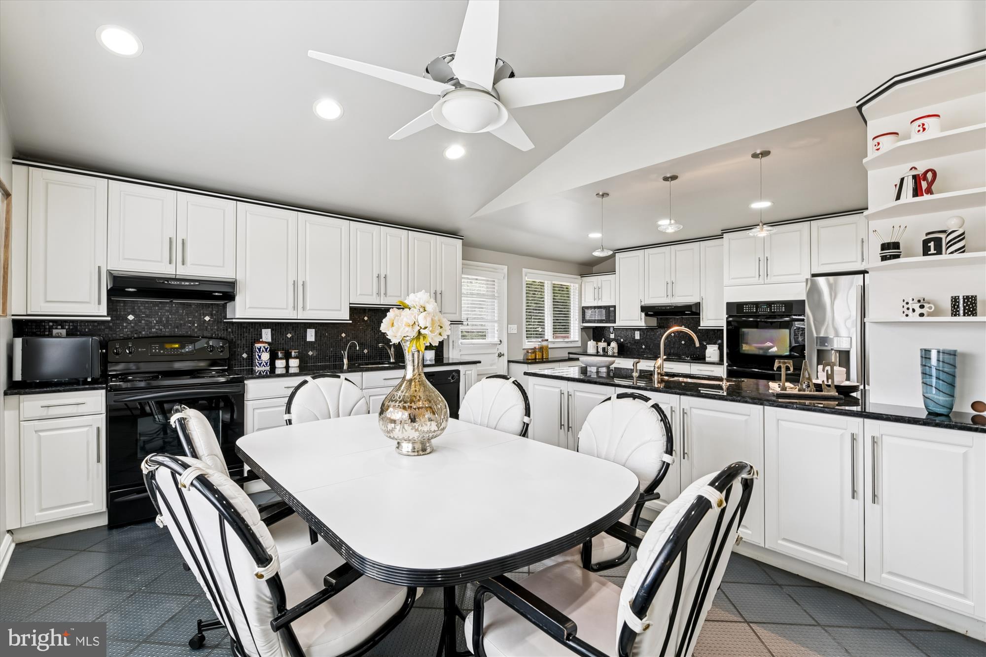 3309 Olympia Avenue Baltimore, MD 21215 - Photo 13 of 41 a kitchen with stainless steel appliances granite countertop a dining table chairs refrigerator and microwave