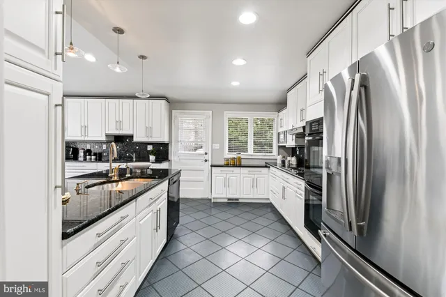 a kitchen with stainless steel appliances granite countertop a refrigerator and a sink