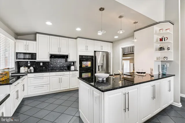 a kitchen with stainless steel appliances granite countertop a sink and cabinets
