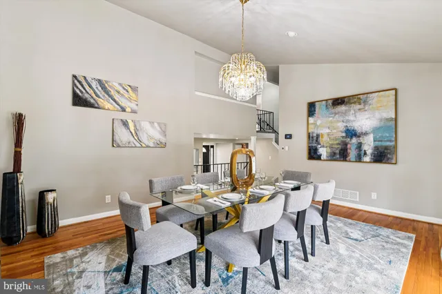 a view of a dining room with furniture a chandelier and wooden floor