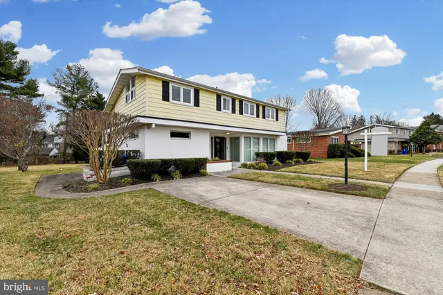 a view of a house with a big yard and large tree