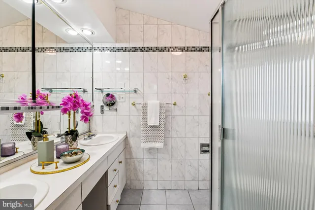a bathroom with a granite countertop sink a potted plant and shower