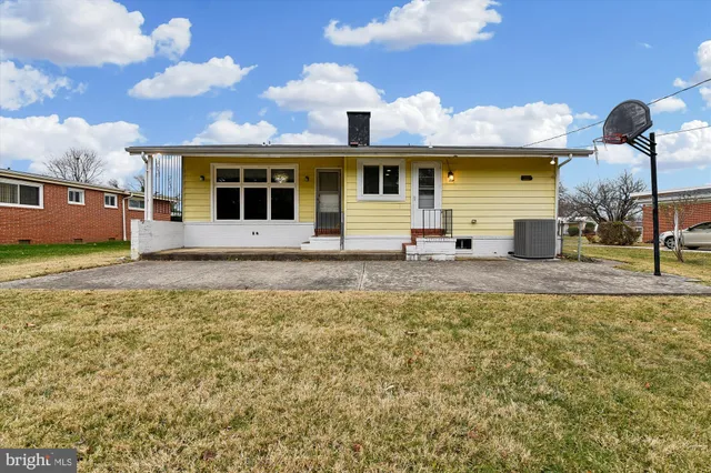 a view of a house with a big yard and large trees