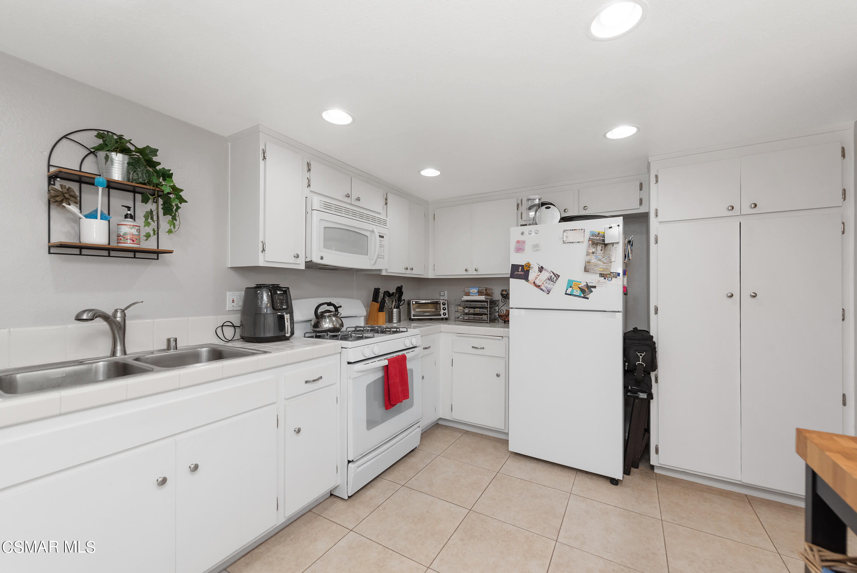 3369 Manorgate Place Simi Valley, CA 93065 - Photo 13 of 29 a kitchen with white cabinets and white appliances