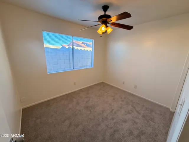 an empty room with a ceiling fan and fan