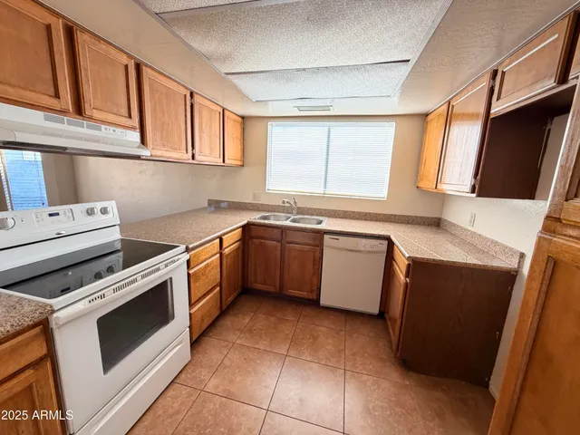a kitchen with a stove sink and cabinets