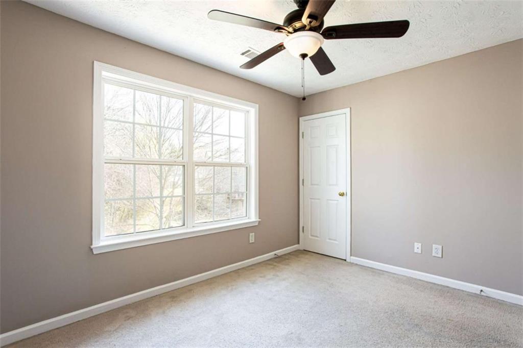 3721 Bogan Mill Road Northeast Buford, GA 30519 - Photo 35 of 58 an empty room with a window and a fan