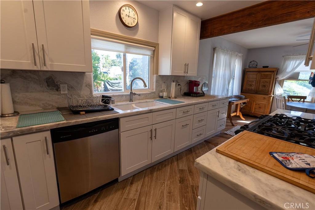 258 West Escalones, Unit 6R San Clemente, CA 92672 - Photo 12 of 22 a kitchen with stainless steel appliances granite countertop a sink stove and cabinets