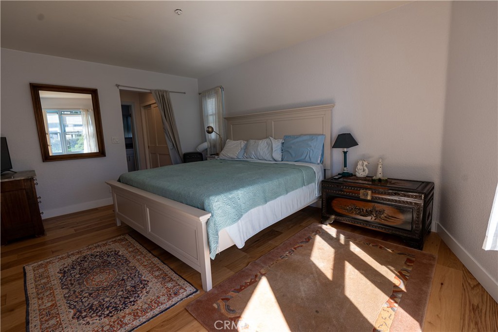 258 West Escalones, Unit 6R San Clemente, CA 92672 - Photo 18 of 22 a bedroom with a bed and wooden floor