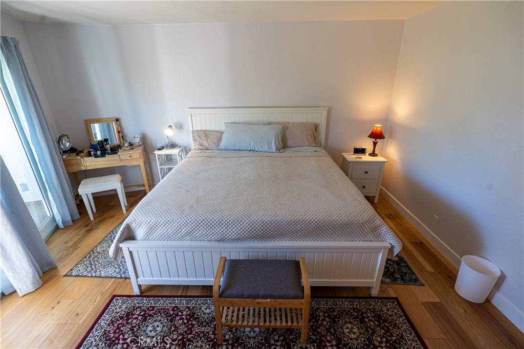 258 West Escalones, Unit 6R San Clemente, CA 92672 - Photo 20 of 22 a bedroom with a bed and wooden floor