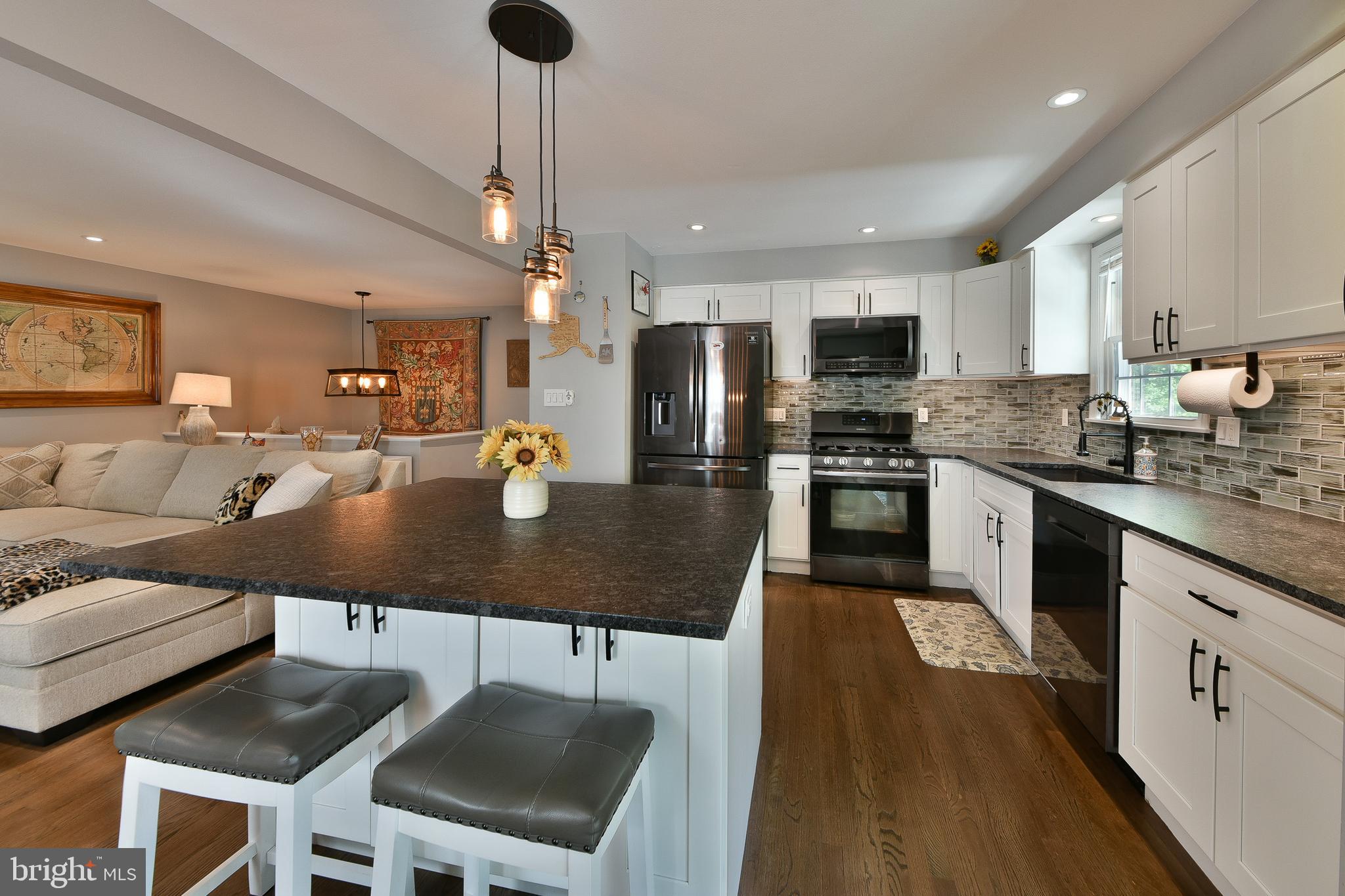 192 Bull Run Road Ewing, NJ 08638 - Photo 12 of 46 a kitchen with stainless steel appliances granite countertop a stove top oven a sink dishwasher a dining table and chairs with wooden floor