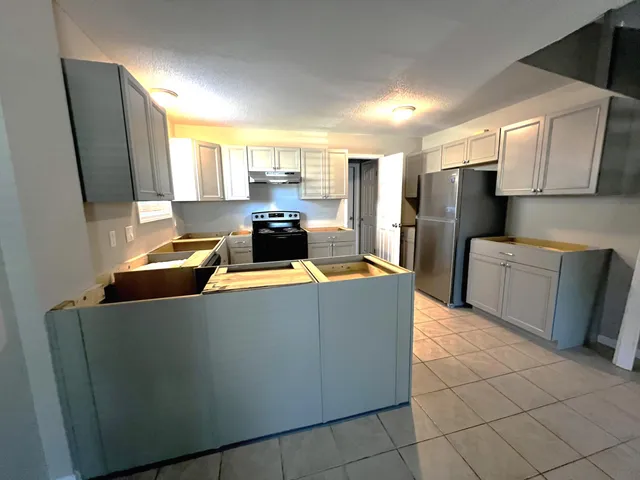 a view of kitchen with stainless steel appliances a refrigerator and a stove top oven