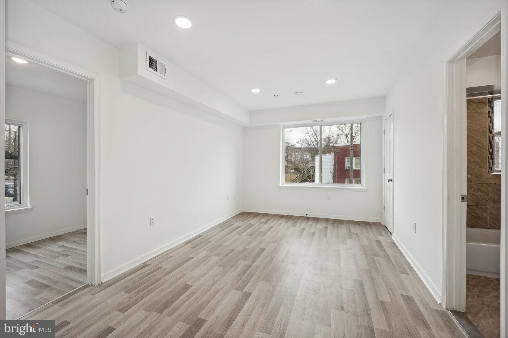 1642 16th Street Southeast, Unit 3 Washington, DC 20020 - Photo 18 of 22 an empty room with wooden floor and windows