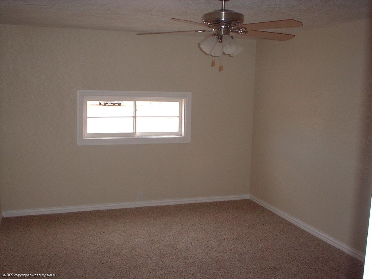 4200 South Tyler Street Amarillo, TX 79110 - Photo 4 of 8 an empty room with a window and a fan