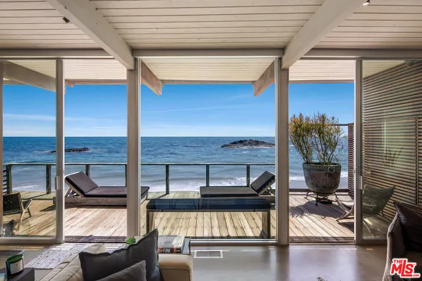 a view of a porch with furniture and floor to ceiling window