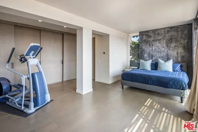 a bedroom with furniture and a gym machine