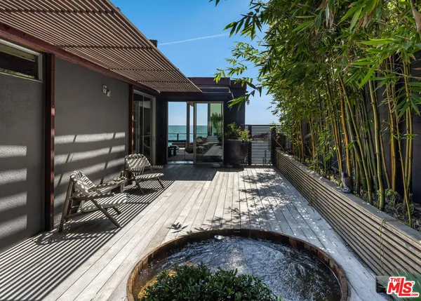 a view of a patio with table and chairs with wooden floor and fence