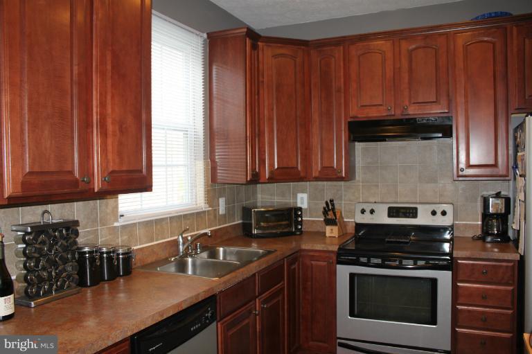 707 MacDill Road Baltimore, MD 21220 - Photo 1 of 20 a kitchen with stainless steel appliances granite countertop a stove a sink dishwasher and cabinets with wooden floor