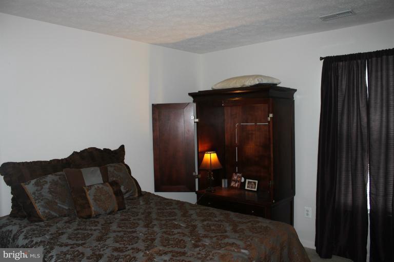 707 MacDill Road Baltimore, MD 21220 - Photo 8 of 20 a bed room with a bed and a mirror