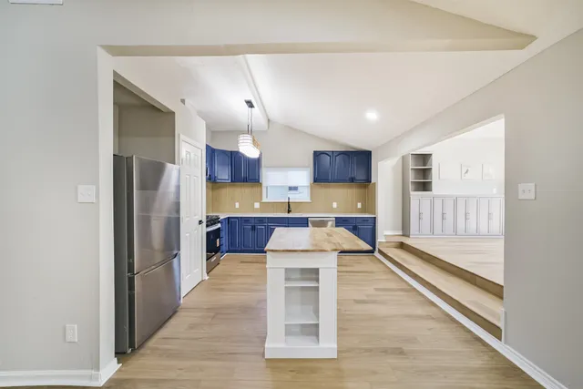 a living room with stainless steel appliances kitchen island granite countertop furniture wooden floor and a view of kitchen
