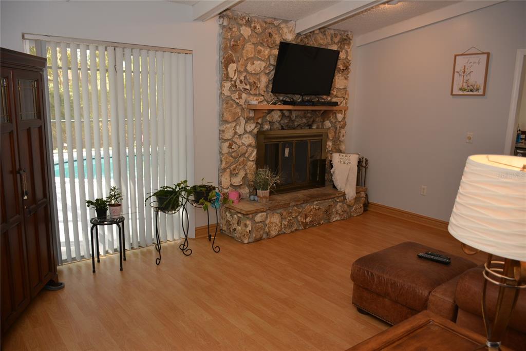 308 Tangerine Street Altamonte Springs, FL 32701 - Photo 34 of 58 Family room (12x17) with laminate floors, fireplace and vaulted ceiling overlooks the screened lanai, pool and backyard