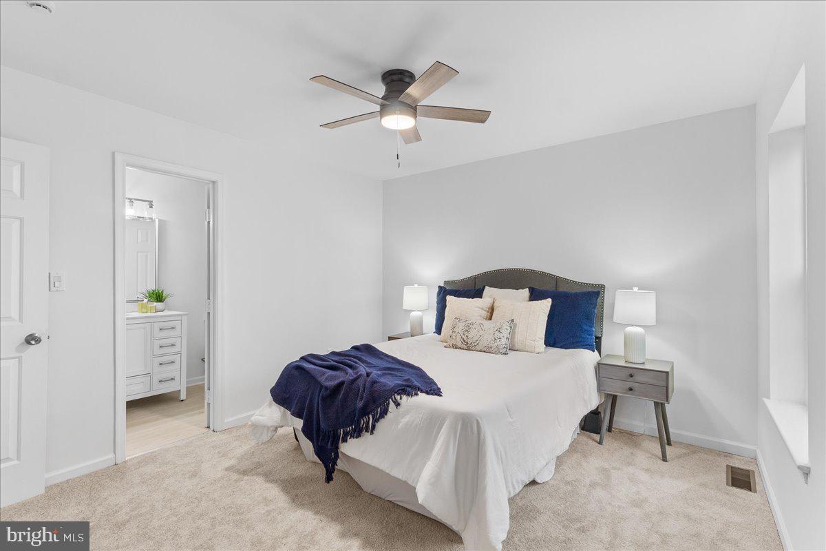 2227 Rock Creek Road Fredericksburg, VA 22407 - Photo 16 of 31 a bedroom with a bed and a chandelier