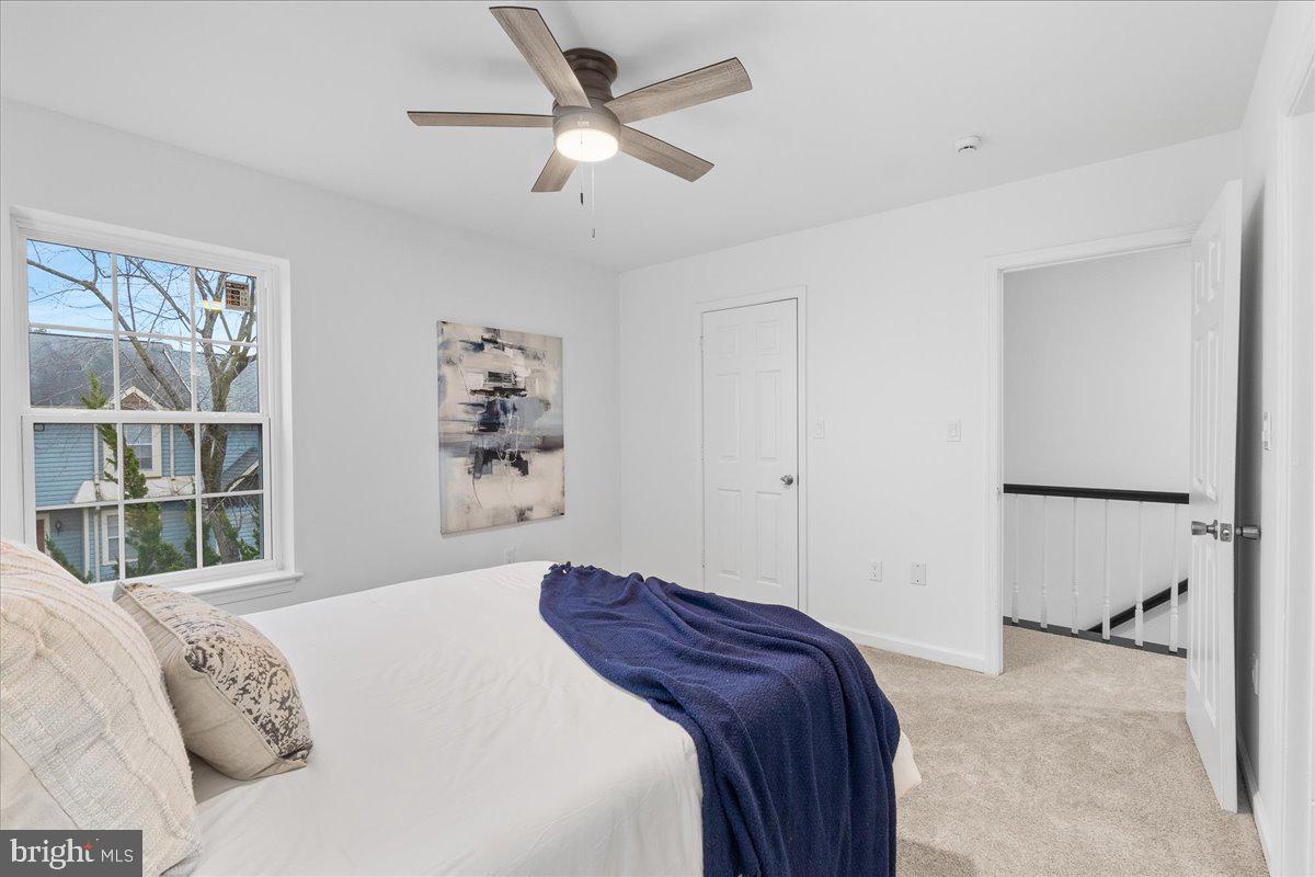2227 Rock Creek Road Fredericksburg, VA 22407 - Photo 17 of 31 a bedroom with a large bed and a chandelier fan