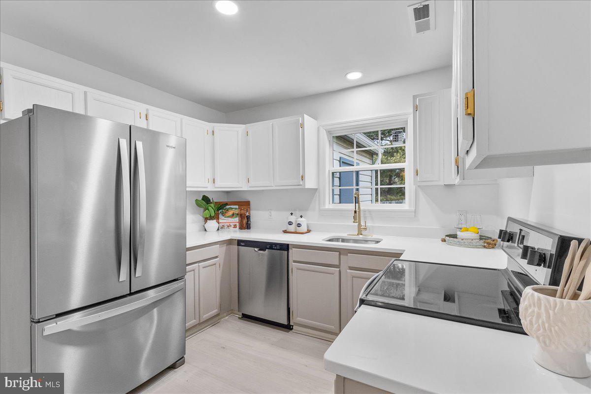 2227 Rock Creek Road Fredericksburg, VA 22407 - Photo 10 of 31 a kitchen with a sink a refrigerator and cabinets