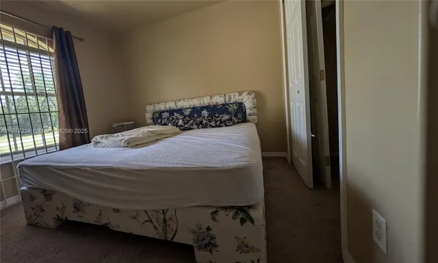 a bed sitting in a bedroom next to a window