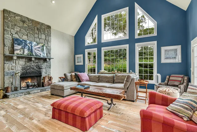 a living room with furniture large window and fireplace