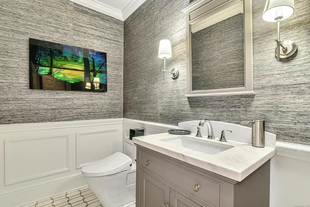 a bathroom with a sink a toilet and mirror