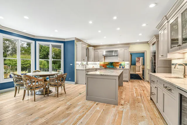a living room with stainless steel appliances granite countertop furniture wooden floor and a rug