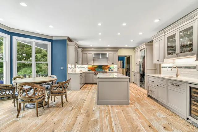 a dining hall with stainless steel appliances granite countertop a stove and a sink