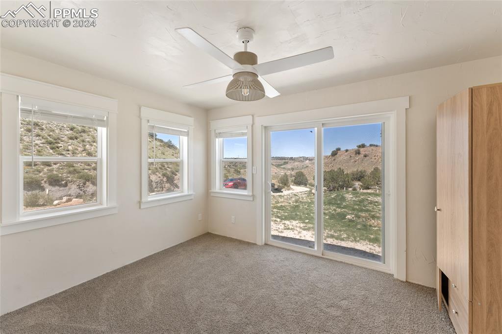 659 Turrell Trail Penrose, CO 81240 - Photo 4 of 19 a view of an empty room with windows and chandelier fan