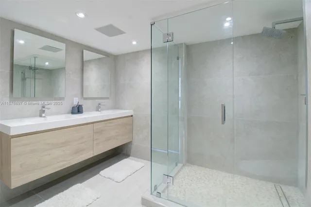 a bathroom with a double vanity sink mirror and shower