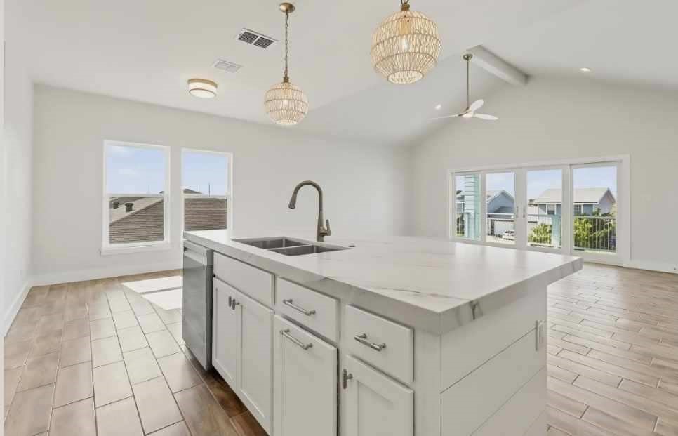 15206 Cruiser Street Corpus Christi, TX 78418 - Photo 7 of 10 a kitchen with a sink dishwasher a stove and a dining table with wooden floor