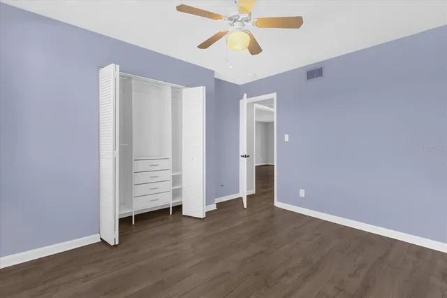 an empty room with wooden floor and closet area