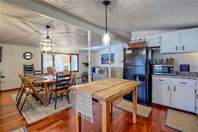 a living room with furniture two window and wooden floor