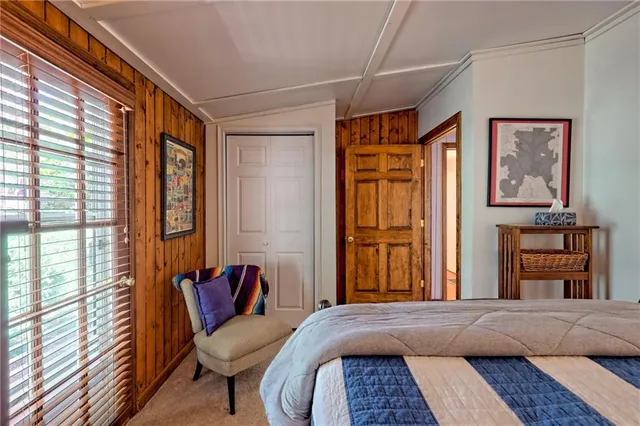 a bedroom with a bed and a dresser next to a window