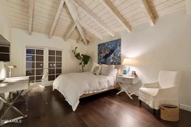 a spacious bedroom with a bed and glass window