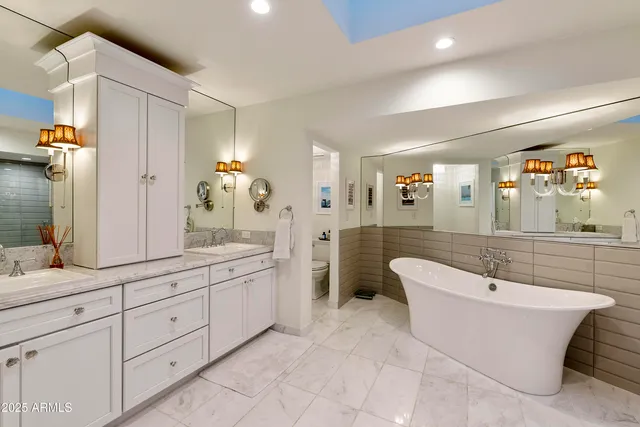 a spacious bathroom with a double vanity sink a mirror a bathtub and shower