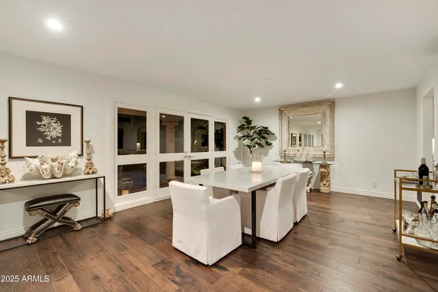 a living room with fireplace furniture and a dining table with wooden floor