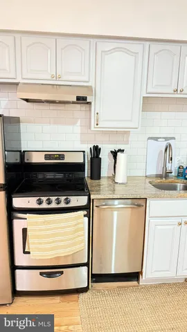 a kitchen with a stove and white cabinets